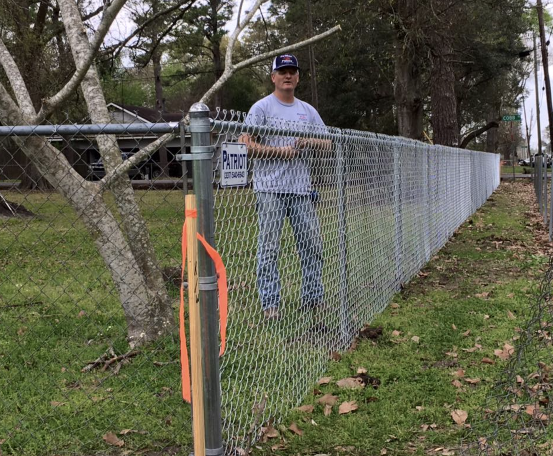Chain-link fence installation with Patriot Fence Company sign